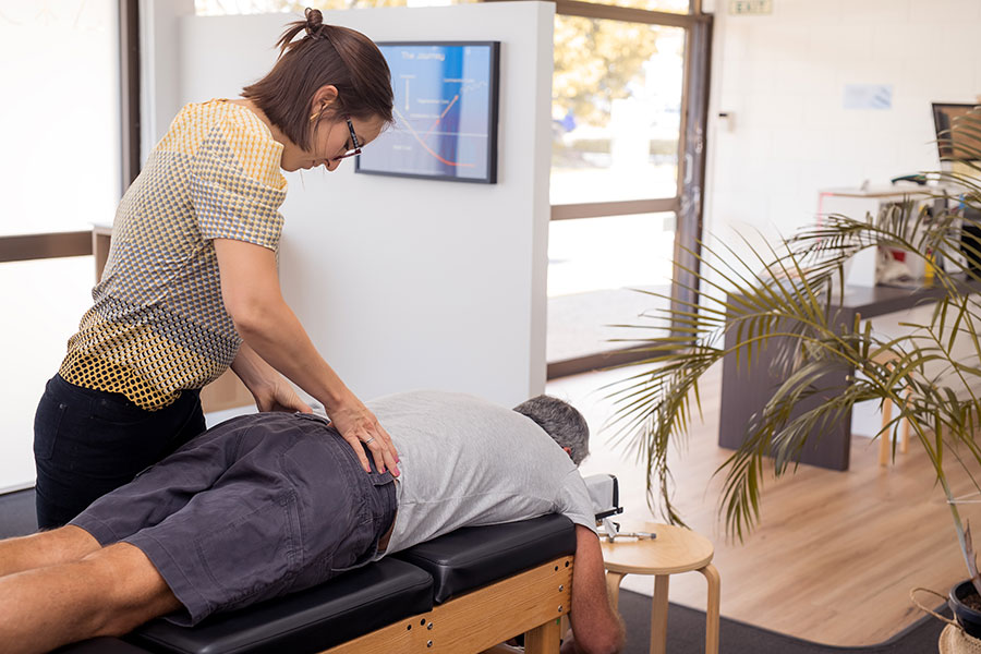 chiropractor adjusting a man's back