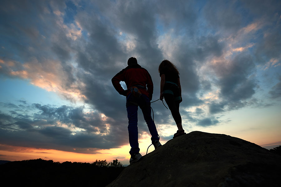 a man and a woman watch a sunset